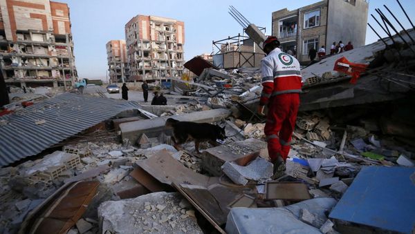 In this photo provided by the Iranian Students News Agency, ISNA, a rescue worker searches debris for survivors with his sniffing dog after an earthquake at the city of Sarpol-e-Zahab in western Iran, Monday, Nov. 13, 2017 In this photo provided by the Iranian Students News Agency, ISNA, a rescue worker searches debris for survivors with his sniffing dog after an earthquake at the city of Sarpol-e-Zahab in western Iran, Monday, Nov. 13, 2017 - Sputnik International