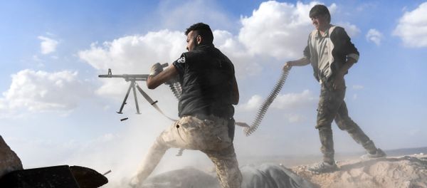 A member of the Syrian pro-regime forces fires a machine gun as a comrade holds his feeding ammunition belt, during the advance towards rebel-held positions west of Aleppo, near Abu al-Zuhur military airport in the Idlib province countryside, on November 11, 2017 A member of the Syrian pro-regime forces fires a machine gun as a comrade holds his feeding ammunition belt, during the advance towards rebel-held positions west of Aleppo, near Abu al-Zuhur military airport in the Idlib province countryside, on November 11, 2017 - Sputnik International