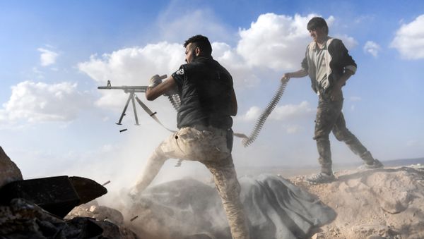 A member of the Syrian pro-regime forces fires a machine gun as a comrade holds his feeding ammunition belt, during the advance towards rebel-held positions west of Aleppo, near Abu al-Zuhur military airport in the Idlib province countryside, on November 11, 2017 - Sputnik International