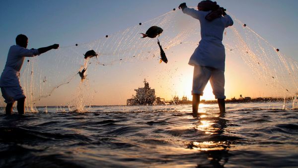 Fishermen check their nets for the day's catch as an oil tanker is seen in the distance near the port in the north-western city of Dubai (File) - Sputnik International