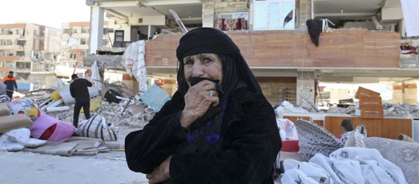 An earthquake survivor weeps as she sits in front of damaged buildings, in a compound which was built under the Mehr state-owned program, in Sarpol-e-Zahab in western Iran, Tuesday, Nov. 14, 2017 - Sputnik International