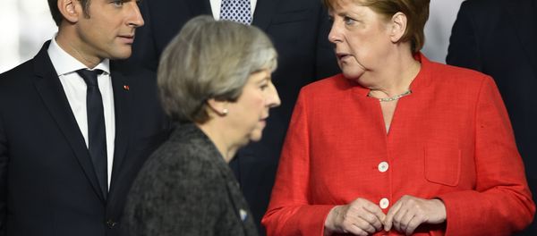 Britain's Prime Minister Theresa May, foreground walks by French President Emmanuel Macron, left, and German Chancellor Angela Merkel as they gather with NATO member leaders to pose for a group photo, prior to the start of their summit in Brussels, Belgium, Thursday, May 25, 2017. Britain's Prime Minister Theresa May, foreground walks by French President Emmanuel Macron, left, and German Chancellor Angela Merkel as they gather with NATO member leaders to pose for a group photo, prior to the start of their summit in Brussels, Belgium, Thursday, May 25, 2017. - Sputnik International