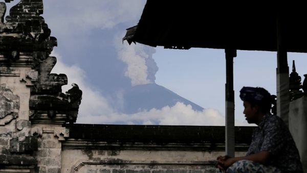 A Balinese man sits as Mount Agung volcano erupts at Lempuyang Temple in Karangasem, Bali, Indonesia November 27, 2017 A Balinese man sits as Mount Agung volcano erupts at Lempuyang Temple in Karangasem, Bali, Indonesia November 27, 2017 - Sputnik International