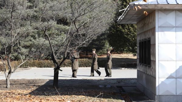 Three North Korean soldiers look at the South side at the spot where a North Korean soldier crossed the border at the Panmunjom in the Demilitarized Zone, South Korea Three North Korean soldiers look at the South side at the spot where a North Korean soldier crossed the border at the Panmunjom in the Demilitarized Zone, South Korea - Sputnik International