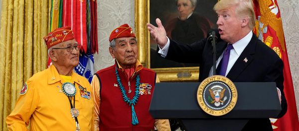 U.S. President Donald Trump gestures as he hosts an event honouring the Native American code talkers, including Thomas Begay (L) and Peter McDonald, in front of a painting of President Andrew Jackson, at the White House in Washington, U.S., November 27, 2017. - Sputnik International