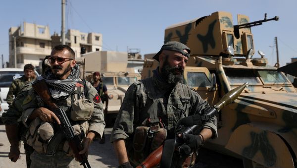 A fighter of the Syrian Democratic Forces (SDF) carries a weapon as he stands near a military vehicle in Raqqa, Syria, October 16, 2017 - Sputnik International
