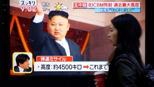 A woman walks past a street monitor showing North Korea's leader Kim Jong Un in a news report about North Korea's missile launch, in Tokyo, Japan, November 29, 2017 - Sputnik International