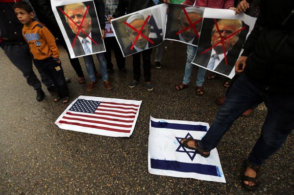 A Palestinian man steps on a representation of an Israeli flag as other demonstrators hold crossed out posters of US President Donald Trump and Israeli Prime Minister Benjamin Netanyahu during a protest against the U.S. intention to move its embassy to Jerusalem and to recognize the city of Jerusalem as the capital of Israel, in Rafah in the southern Gaza Strip December 6, 2017. - Sputnik International