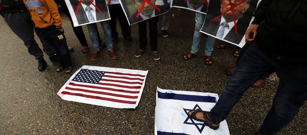 A Palestinian man steps on a representation of an Israeli flag as other demonstrators hold crossed out posters of US President Donald Trump and Israeli Prime Minister Benjamin Netanyahu during a protest against the U.S. intention to move its embassy to Jerusalem and to recognize the city of Jerusalem as the capital of Israel, in Rafah in the southern Gaza Strip December 6, 2017. A Palestinian man steps on a representation of an Israeli flag as other demonstrators hold crossed out posters of US President Donald Trump and Israeli Prime Minister Benjamin Netanyahu during a protest against the U.S. intention to move its embassy to Jerusalem and to recognize the city of Jerusalem as the capital of Israel, in Rafah in the southern Gaza Strip December 6, 2017. - Sputnik International