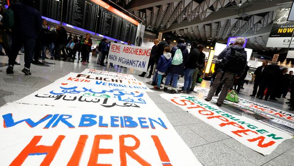 Protestors display placards reading We stay here, No deportation to Afghanistan and Fleeing is not a crime as they demonstrate against the deportation of people to Afghanistan at Fraport airport in Frankfurt, Germany, December 6, 2017 Protestors display placards reading We stay here, No deportation to Afghanistan and Fleeing is not a crime as they demonstrate against the deportation of people to Afghanistan at Fraport airport in Frankfurt, Germany, December 6, 2017 - Sputnik International