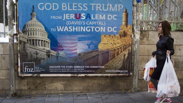A woman walks past a poster praising U.S. President Donald Trump’s recognition of Jerusalem as Israel’s capital, in Jerusalem, Thursday, Dec. 7, 2017 - Sputnik International