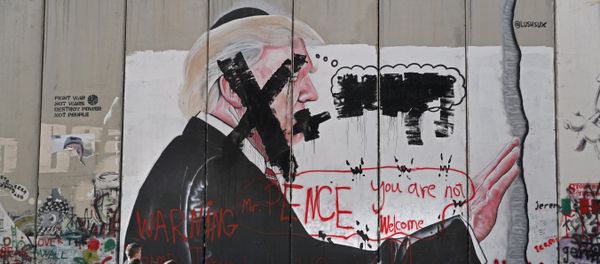 Palestinian children look at vandalised graffiti depicting US President Donald Trump and slogans against US Vice President Mike Pence painted on Israel's controversial separation barrier in the West Bank city of Bethlehem during clashes with Palestinian protestors near an Israeli checkpoint on December 7, 2017 - Sputnik International