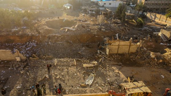Palestinians look at the damage at a Hamas military facility early on December 9, 2017, in the aftermath of an Israeli air strike in Beit Lahia, in the northern Gaza Strip - Sputnik International