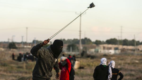 A Palestinian protester hurls a rock at Israeli forces during clashes near the Israel-Gaza border east of Gaza City on December 9, 2017 A Palestinian protester hurls a rock at Israeli forces during clashes near the Israel-Gaza border east of Gaza City on December 9, 2017 - Sputnik International