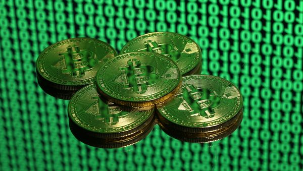 Tokens of the virtual currency Bitcoin are seen placed on a monitor that displays binary digits in this illustration picture, December 8, 2017 Tokens of the virtual currency Bitcoin are seen placed on a monitor that displays binary digits in this illustration picture, December 8, 2017 - Sputnik International