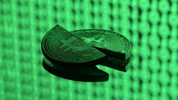 Broken representations of the Bitcoin virtual currency, placed on a monitor that displays binary digits, are seen in this illustration picture, December 8, 2017. Picture taken December 8 - Sputnik International
