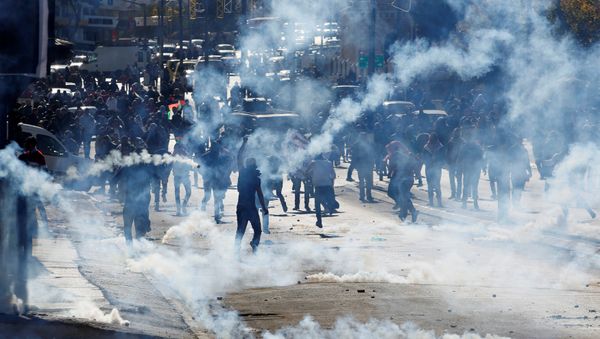 Palestinian demonstrators react to tear gas fired by Israeli troops during clashes at a protest against U.S. President Donald Trump's decision to recognize Jerusalem as the capital of Israel, in the West Bank city of Bethlehem December 9, 2017 Palestinian demonstrators react to tear gas fired by Israeli troops during clashes at a protest against U.S. President Donald Trump's decision to recognize Jerusalem as the capital of Israel, in the West Bank city of Bethlehem December 9, 2017 - Sputnik International