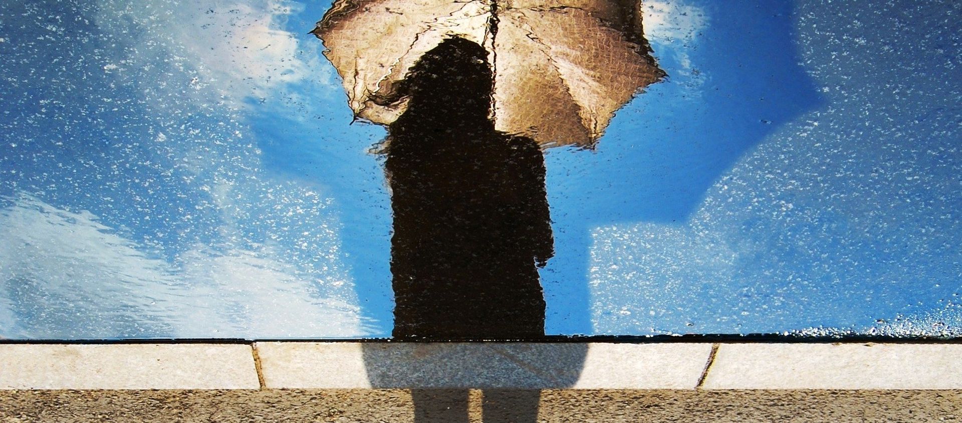 A silhouette of a woman holding an umbrella A silhouette of a woman holding an umbrella - Sputnik International, 1920, 12.12.2017