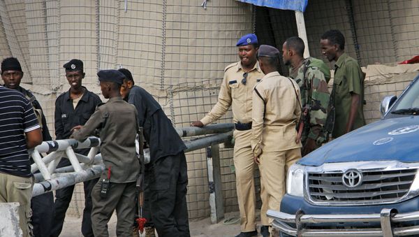 Somali police guard the road leading to the scene of a suicide bomb attack on a police academy in the capital Mogadishu, Somalia Thursday, Dec. 14, 2017 - Sputnik International