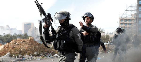 Israeli police officers walk in front of a burned barricade during a protest against U.S. President Donald Trump's decision to recognize Jerusalem as the capital of Israel, near the Jewish settlement of Beit El, near the West Bank city of Ramallah December 11, 2017 - Sputnik International
