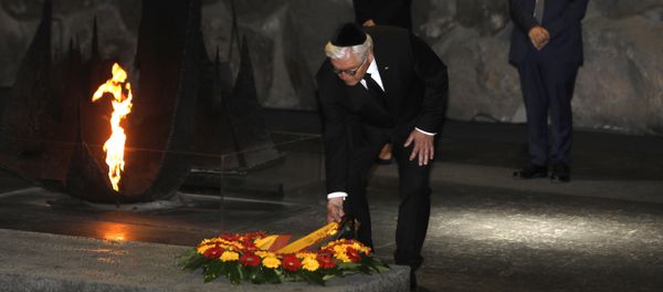 German President Frank-Walter Steinmeier (C), escorted by his wife Elke Budenbender (L) and the chairman of the Yad Vashem Holocaust Memorial museum, Avner Shalev (R), lays a wreath at the Hall of Remembrance, where the names of major death and concentration camps are written, during his visit to Yad Vashem commemorating the six million Jews killed by Nazis during World War II, in Jerusalem on May 7, 2017 - Sputnik International
