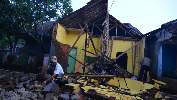 A man cleans up the wreckage of a house damaged by an earthquake in Sumelap Village, Tasikmalaya City, West Java, Indonesia December 16, 2017 in this photo taken by Antara Foto - Sputnik International