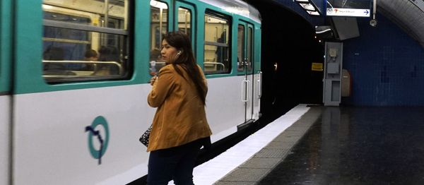 A woman waits the metro on the platform, next to a play on words made with the Jussieu metro station, reading I'm here to stay, in Paris, on April 1, 2017 - Sputnik International