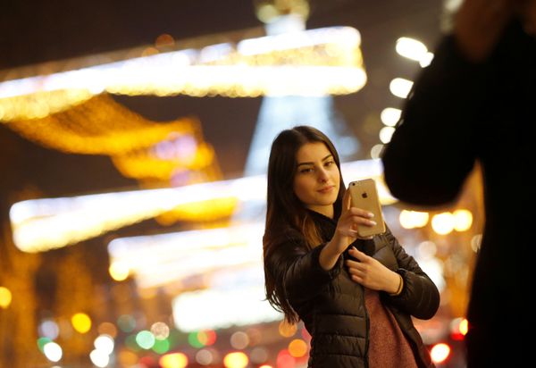 A woman takes a selfie on a street with Christmas decoration in Tbilisi, Georgia - Sputnik International