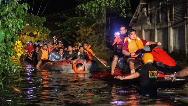 Rescue workers evacuate flood-affected residents in Davao on the southern Philippine island of Mindanao early on December 23, 2017, after Tropical Storm Tembin dumped torrential rains across the island. The death toll from the tropical storm that struck the southern Philippines has risen to 30 with five others missing, officials said on December 23 - Sputnik International