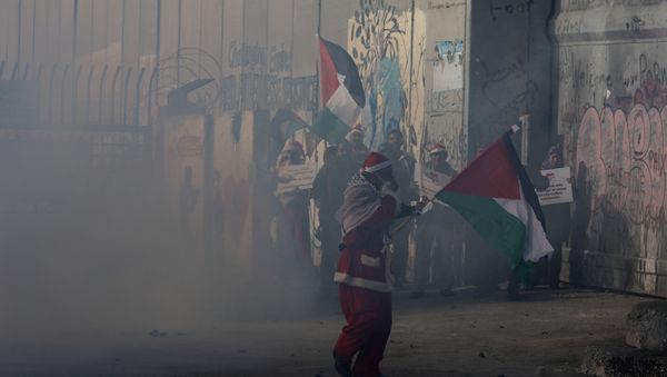 A Palestinian dressed as Santa Claus reacts from tear gas fired by Israeli troops during clashes in the West Bank city of Bethlehem, December 23, 2017 A Palestinian dressed as Santa Claus reacts from tear gas fired by Israeli troops during clashes in the West Bank city of Bethlehem, December 23, 2017 - Sputnik International