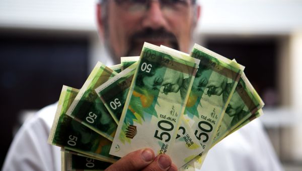 An employee of Bank of Israel holds new 50 Shekels' bills during a press conference at the bank's headquarters in Jerusalem on September 10 2014 - Sputnik International