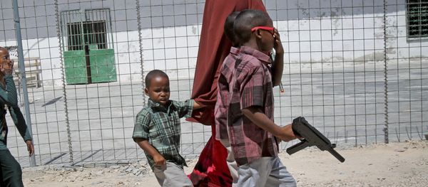In this photo taken Saturday, Oct 4, 2014, a Somali mother walks with her children, one carrying a plastic toy gun, towards an area with children's toys to play with at the Mogadishu Guest House, in Mogadishu, Somalia - Sputnik International