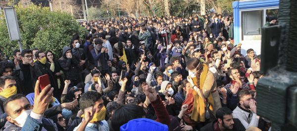 In this photo taken by an individual not employed by the Associated Press and obtained by the AP outside Iran, university students attend a protest inside Tehran University while anti-riot Iranian police prevent them to join other protestors, in Tehran, Iran, Saturday, Dec. 30, 2017 - Sputnik International