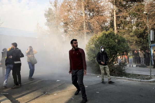 Iran, university students attend a protest inside Tehran University while a smoke grenade is thrown by anti-riot Iranian police, in Tehran, Iran, Saturday, Dec. 30, 2017 - Sputnik International