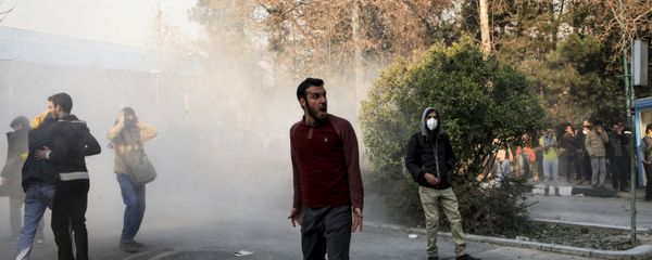 Iran, university students attend a protest inside Tehran University while a smoke grenade is thrown by anti-riot Iranian police, in Tehran, Iran, Saturday, Dec. 30, 2017 - Sputnik International