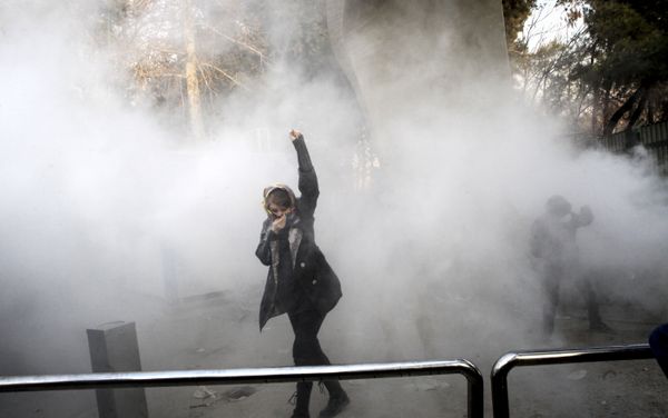FILE - In this Saturday, Dec. 30, 2017 file photo taken by an individual not employed by the Associated Press and obtained by the AP outside Iran, a university student attends a protest inside Tehran University while a smoke grenade is thrown by anti-riot Iranian police, in Tehran, Iran FILE - In this Saturday, Dec. 30, 2017 file photo taken by an individual not employed by the Associated Press and obtained by the AP outside Iran, a university student attends a protest inside Tehran University while a smoke grenade is thrown by anti-riot Iranian police, in Tehran, Iran - Sputnik International