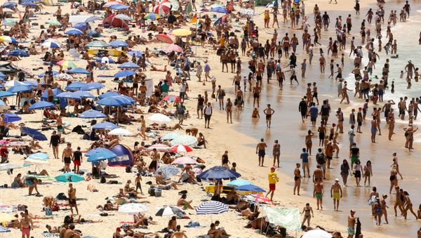 Beachgoers sit and walk in the water at Sydney's Bondi Beach on a hot summer day in Australia, January 7, 2018 Beachgoers sit and walk in the water at Sydney's Bondi Beach on a hot summer day in Australia, January 7, 2018 - Sputnik International