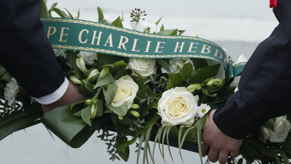 French police officers hold a wreath of flowers before a ceremony outside the kosher grocery where Amedy Coulibaly killed four people, during the third anniversary of the attack, in Paris, Sunday, Jan. 7, 2018 - Sputnik International