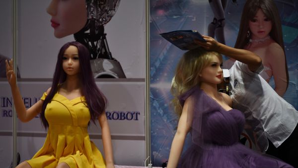 An exhibitor (R) adjusts an adult sex toy doll at her stall during the Asia Adult Expo in Hong Kong. (File) - Sputnik International