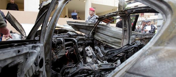 Lebanese policemen are seen next to a damaged car in Sidon, southern Lebanon, January 14, 2018. - Sputnik International