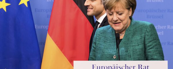 French President Emmanuel Macron, left, passes by German Chancellor Angela Merkel prior to addressing a media conference at an EU summit in Brussels on Friday, Dec. 15, 2017. - Sputnik International