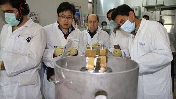 Unidentified International Atomic Energy Agency (IAEA) inspectors and Iranian technicians are on hand to cut the connections between the twin cascades for 20 percent uranium enrichment at Natanz facility, some 200 miles (322 kilometers) south of the capital Tehran, Iran, Monday, Jan. 20, 2014 - Sputnik International