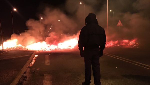 Hooded man looks on at the scene from the Fleury-Mérogis prison guard protest - Sputnik International