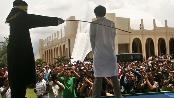 A Sharia law official whips a man , Aceh province, Indonesia (File) - Sputnik International