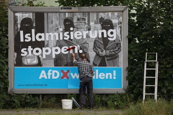 A man sticks an Alternative for Germany (AfD)'s electoral poster reading stop islamization in Berlin on September 7, 2017 A man sticks an Alternative for Germany (AfD)'s electoral poster reading stop islamization in Berlin on September 7, 2017 - Sputnik International