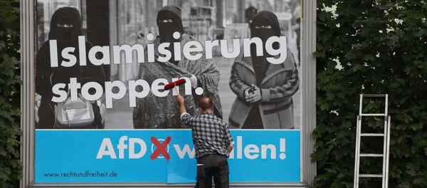 A man sticks an Alternative for Germany (AfD)'s electoral poster reading stop islamization in Berlin on September 7, 2017 A man sticks an Alternative for Germany (AfD)'s electoral poster reading stop islamization in Berlin on September 7, 2017 - Sputnik International