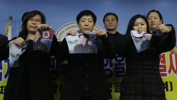 North Korean defectors tear portraits of North Korean leader Kim Jong Un during a press conference against the North Korea's participation in the 2018 Pyeongchang Winter Olympics at the National Assembly in Seoul, South Korea, Wednesday, Jan. 24, 2018 - Sputnik International