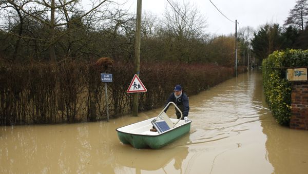A resident pushes a dinghy boat in a flooded street of Esbly, east of Paris, where the Grand Morin river floods - Sputnik International