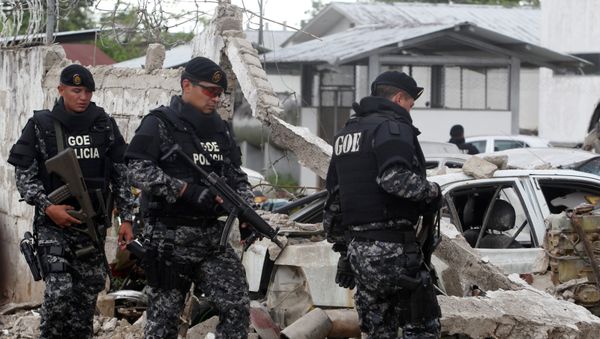 Police officers walk past damaged vehicles at the scene of a bomb explosion at a police station in San Lorenzo - Sputnik International