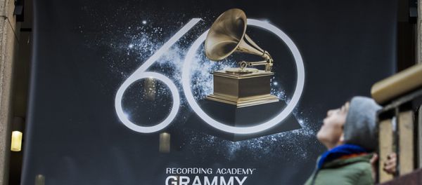 A young boy walks past advertisements promoting the 60th Annual Grammy Awards at the Madison Square Garden in New York on January 26, 2018 - Sputnik International